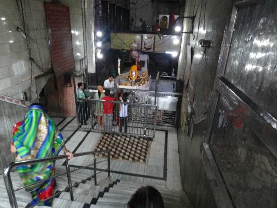 Devotees descending the stone steps that lead down from street level into the subterranean sanctum